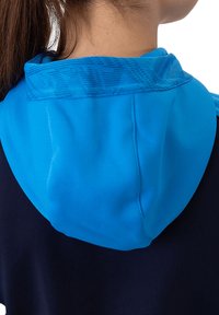 Sportieve hoodie-jack met een blauwe capuchon met een gestructureerd patroon, een marineblauw lijf en een gladde stofafwerking.