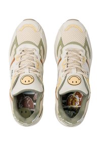 Beige mesh joggesko med olivengrønne og brune detaljer, rund smiley-logo på tungen, mønstret indersål, tekstureret gummisål.