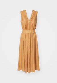 Une robe sans manches, décolletée en V dans une teinte orange chaud, avec des plis et une taille ceinturée ornée de petits clous. Tissu lisse et léger.