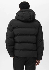 Giacca a vento nera con cappuccio, dotata di design trapuntato e imbottitura spessa. Materiale liscio con finitura opaca. Vista posteriore mostrata.