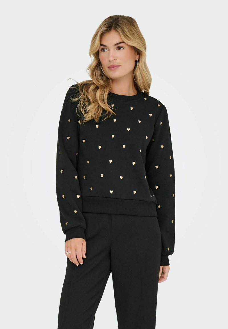 Zwarte sweatshirt met gouden hartpatronen, ronde hals, lange mouwen en een geribde zoom, gecombineerd met zwarte broeken. Gladde textuur.