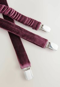 Sammetshängslen i en djup plommonfärg, försedd med en plisserad sektion och klipp av silverfärgad metall för fäste. Slät textur och elegant design.