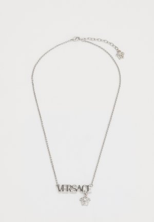 Silver chain necklace featuring "VERSACE" lettering and a small crown charm. The chain is finely linked with an adjustable length.