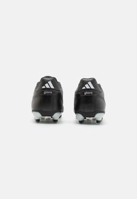 Botas de fútbol negras con parte superior de cuero liso, que presentan acentos blancos, un talón texturizado y tachuelas cónicas para una mejor tracción.
