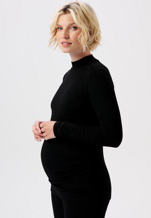 Zwart langslijvend zwangerschapsoberdeel met een hoge hals en geribbelde textuur, ontworpen voor een slanke pasvorm die ruimte biedt aan een groeiende buik.