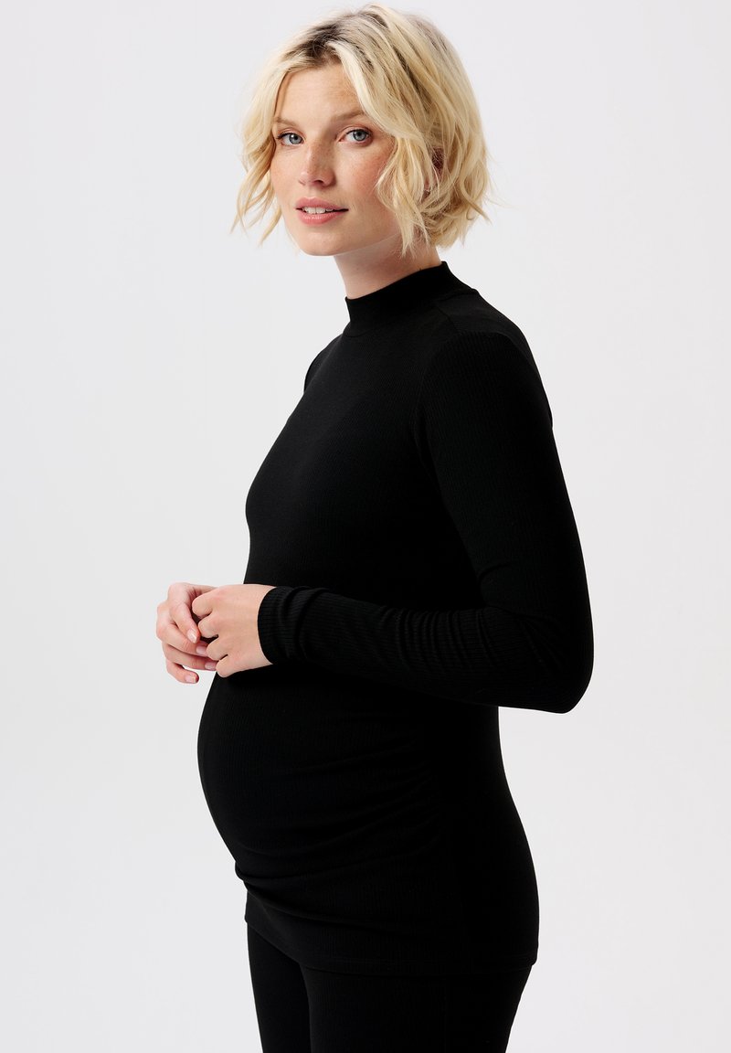 Schwarzes, langärmeliges Umstandsoberteil mit hohem Kragen und gerippter Textur, das für eine enganliegende Passform entworfen wurde, die einen wachsenden Babybauch berücksichtigt.