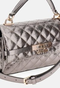 Textuur, metallic zilveren handtas met een quilted ontwerp, gouden hardware, een logo sluiting en een afneembare schouderband.