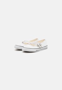 Scarpe da tela bianche con suole a strisce nere, dotate di due cinturini regolabili con fibbie in metallo e design a punta tonda.
