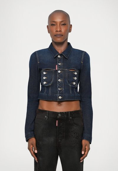 Jachetă din denim închis, tăiată, cu închidere prin butoane, două buzunare pe piept și cusături contrastante; combinată cu blugi negri cu un model subtil.