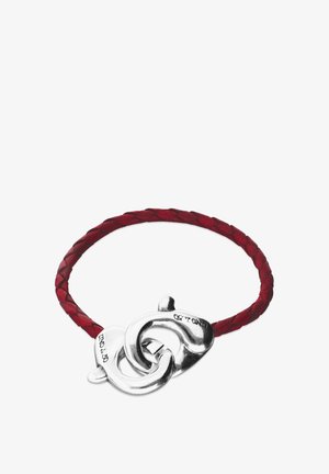 Bracelet en cuir tressé rouge avec fermoir en métal argenté présentant des boucles entrelacées et une finition lisse.