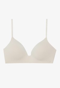 Bra senza cuciture color beige chiaro con spalline regolabili, caratterizzato da un collo a V profondo e un tessuto liscio e elasticizzato. Senza imbottitura né decorazioni.