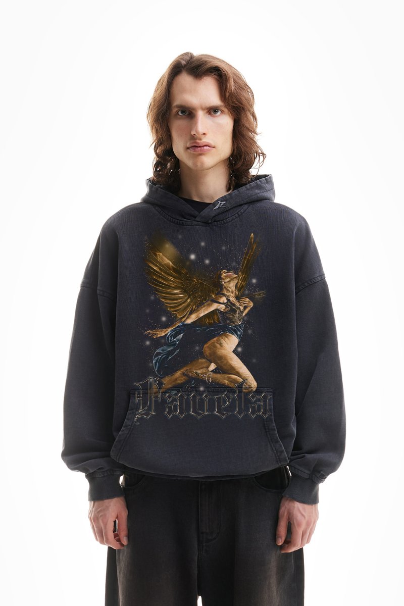 Μαύρη oversized φούτερ με κουκούλα, που απεικονίζει μια γραφική φιγούρα με φτερά και χρυσές λεπτομέρειες. Ο σχεδιασμός περιλαμβάνει αστέρια και τη λέξη "Pavela" σε καλλιγραφική γραμματοσειρά.