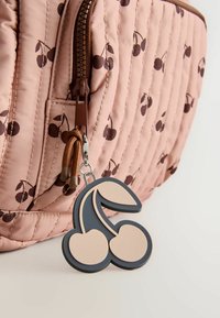 Brown zipper on pink quilted fabric with small brown cherry prints, attached to a beige and dark gray cherry-shaped keychain.