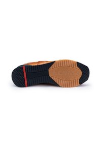 Semelle de chaussure avec un fond en caoutchouc noir présentant un motif en chevrons, un accent en cuir tan et une bande rouge près du talon pour une meilleure adhérence et stabilité.