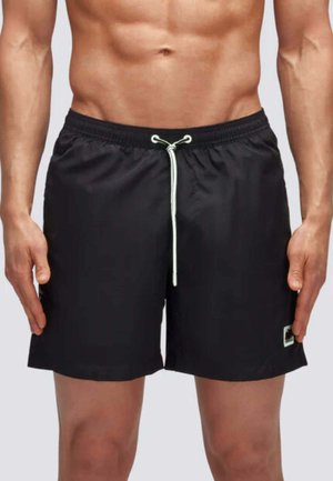 Pantaloni da nuoto neri con vita elastica, chiusura con cordino e tasche laterali. Realizzati in tessuto leggero, con un piccolo logo.