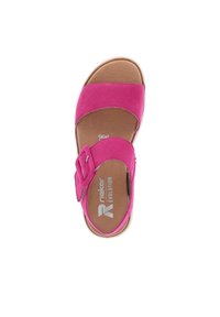 Różowe zamszowe sandały z szerokim paskiem i detalem w postaci klamry, białą gumową podeszwą, wyściełanym wnętrzem oraz tłoczonym logo na wkładce.