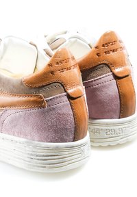 Paire de chaussures décontractées avec des accents en cuir fauve au talon et des côtés en daim violet, présentant des coordonnées embossées sur le talon et les bords de la semelle.