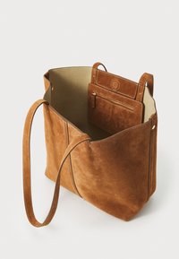 Braune Wildleder-Tote mit zwei langen Tragegriffen und einem geräumigen Innenraum. Beinhaltet ein kleineres Etui mit Reißverschluss, das am Futter der Tasche befestigt ist.