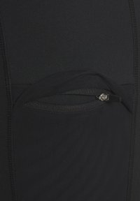 Black athletic legging featuring a secure zippered pocket, smooth texture, and stretchy fabric with flatlock seams for comfort.