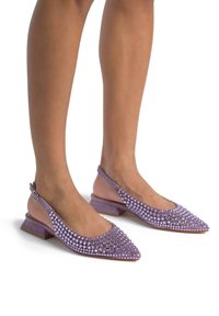 Fioletowe zamszowe buty na obcasie typu slingback z wydłużonym noskiem, ozdobione okrągłymi kryształkami wzdłuż wierzchu, na niskim obcasie typu blok.