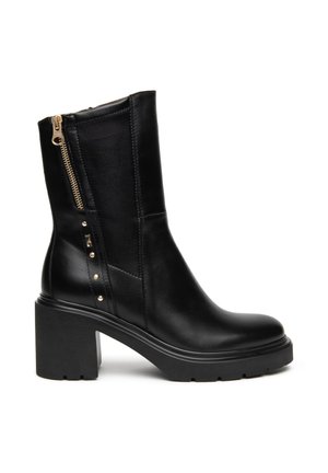 Botte en cuir noir mi-mollet avec talon épais, fermeture éclair latérale, panneau élastique et clous dorés décoratifs sur fond blanc.