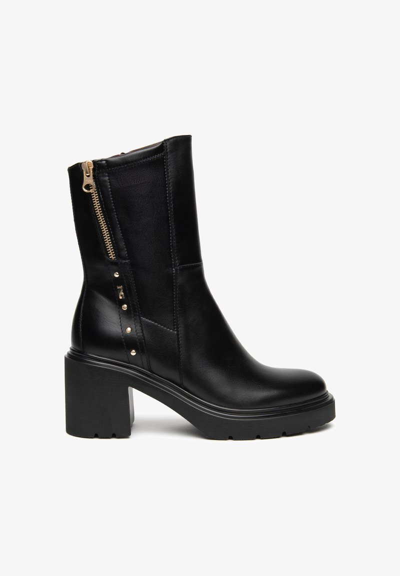 Botte en cuir noir mi-mollet avec talon épais, fermeture éclair latérale, panneau élastique et clous dorés décoratifs sur fond blanc.