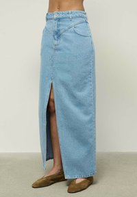 Šviesiai mėlyna džinsinė maksi sijonas su priekiniais įpjovimais, aukštu liemeniu ir vienu sagos uždarymu. Pasižymi šoninėmis kišenėmis ir tiesia siluetu.