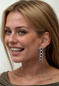 Drop earrings feature blue gemstones set in silver, with a vertical arrangement of four stones bordered by decorative accents.