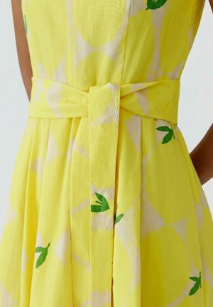 Geel jurkje met citroenenprint, taille ceintuur om te strikken en geplooide rokdetail.