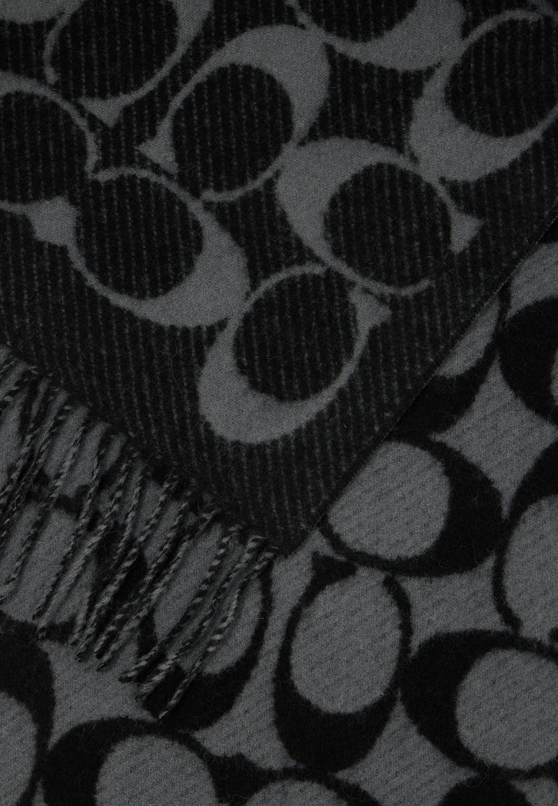 Zwarte en grijze sjaal met een geometrisch patroon van overlappende cirkels, met franjes aan één rand en een zachte, gestructureerde stof.