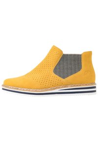 Żółty zamszowy botek do kostki z perforowanym wzorem, tekstylną boczną wkładką i białą podeszwą z niebieskimi i czarnymi paskami.