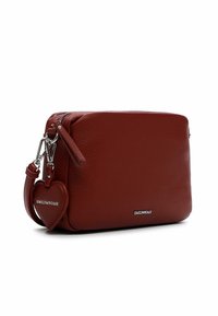 Bolso cruzado de cuero rojo con acabado texturizado, herrajes plateados y charm en forma de corazón extraíble con la marca "EMILY & NOAH".