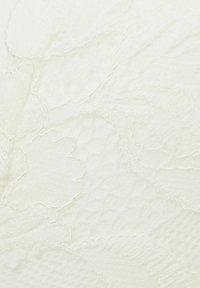Getextureerde ivoorkleurige stof met een bloemenpatroon, met gladde en verhoogde elementen die een subtiel, gelaagd effect creëren.