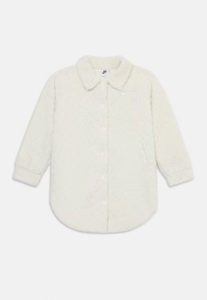 Camisa de botão branca em fleece com colarinho, apresentando um padrão texturizado e um pequeno logótipo da Nike no lado esquerdo do peito.