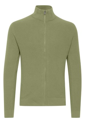 Green ribbed zip-up sweater with a stand collar, long sleeves, and a smooth texture, featuring a central zipper and fitted hem.