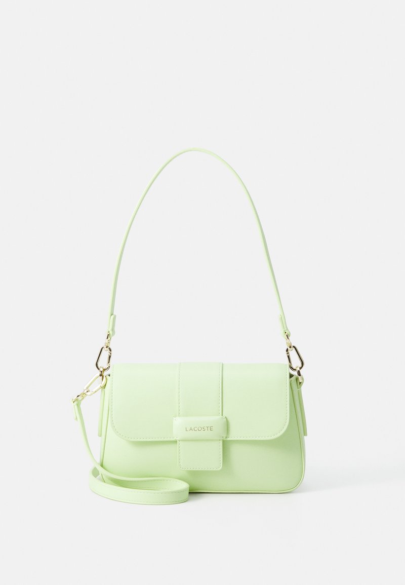 Borsa a tracolla Lacoste in ecopelle verde chiaro, con patta, tracolla con accessori in metallo e un logo prominente sulla parte anteriore.