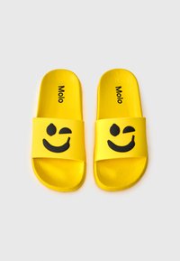 Yellow slides made of rubber with a textured finish. Features a black smiley face design and the word "Molo" printed on each footbed.