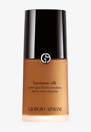 Botella de base de maquillaje Giorgio Armani Luminous Silk con tapa negra y logo en recipiente de vidrio esmerilado en tono marrón medio.