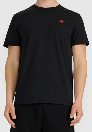 Mężczyzna w gładkiej czarnej koszulce z krótkim rękawem z małym czerwonym logo „4F” na lewej piersi, pokazany od szyi do bioder.