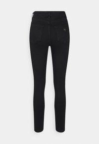 Jeans skinny de mezclilla negra con cintura alta, que cuentan con dos bolsillos traseros y un pequeño acento metálico en el bolsillo derecho.