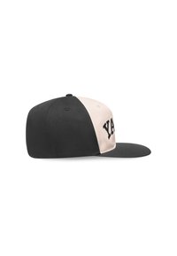 Căciulă snapback neagră și crem cu o margine plată, având cuvântul "YAY" brodat în negru îndrăzneț pe partea din față și o textură netedă.