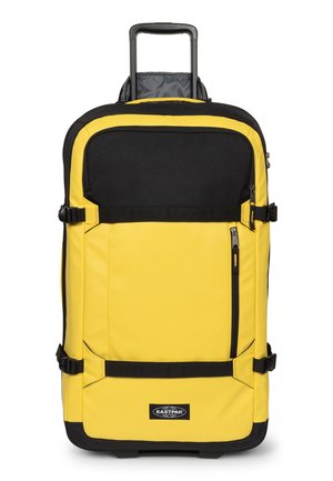 Valise jaune et noire à roulettes avec poignée extensible, poche avant zippée, sangles de compression et logo Eastpak en bas au centre.