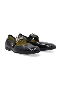 Schwarze Lacklederschuhe mit einem niedrigen Absatz, spitzem Zehenbereich und einem Knöchelriemen mit goldfarbener Hardware und Ösen.