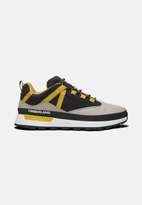 Heren Timberland sneakers hebben een grijze bovenkant van mesh met zwarte en gele accenten, een rubberen zool, een gepolsterde kraag en gedetailleerde textuurpanelen.