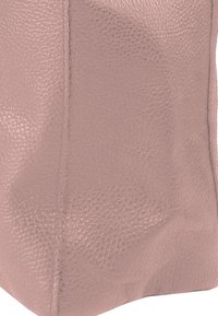 Light pink leather bag with a textured surface and visible stitching. Soft shape with a subtle sheen and no prominent hardware.