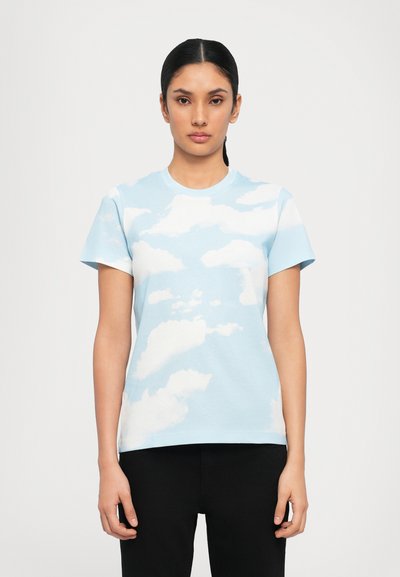 T-shirt en coton bleu clair avec un motif de nuages, à manches courtes et col rond. Le tissu a une texture lisse.