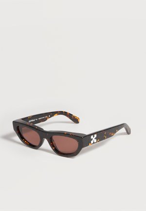 Rechteckige Schildpatt-Sonnenbrille mit braunen Gläsern und weißem Logo an den Bügeln, gezeigt vor einem einfarbigen hellen Hintergrund.