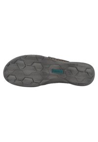 Suola in gomma nera con un motivo a trettaglio esagonale e un'etichetta teal. Design resistente con una superficie testurizzata per una migliore aderenza.