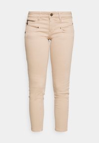 Jean skinny en denim beige avec une taille mi-haute, poches avant et couture décorative. Comprend une petite poche zippée et un bouton en métal.