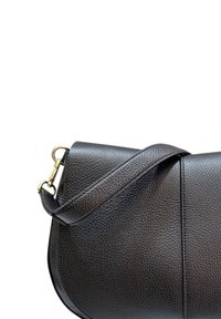 Borsa a mano in pelle nera con texture a granuli, forma curva e una lunga tracolla. Caratterizzata da dettagli in hardware dorato.